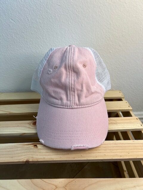 A pink hat sitting on top of a wooden table.