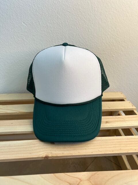 A green and white hat sitting on top of a wooden table.