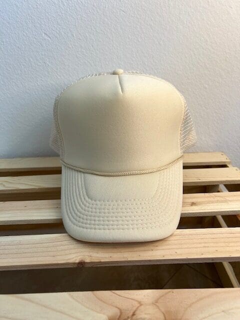 A white hat sitting on top of a wooden bench.